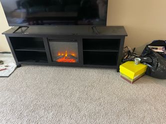TV console w/electric fireplace - it heats the space with a cute fake fire.