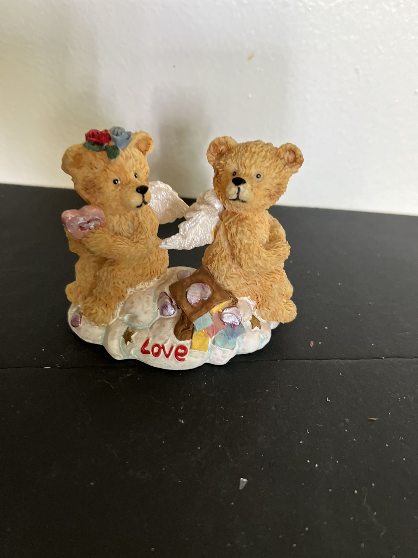 Two angelic teddy bears with wings on a cloud base that says "Love"