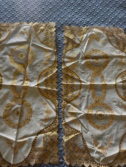 2- pc Gold and cream plastic tablecloth with gold embroidered floral and scrollwork design   New The measurements are 16”x32