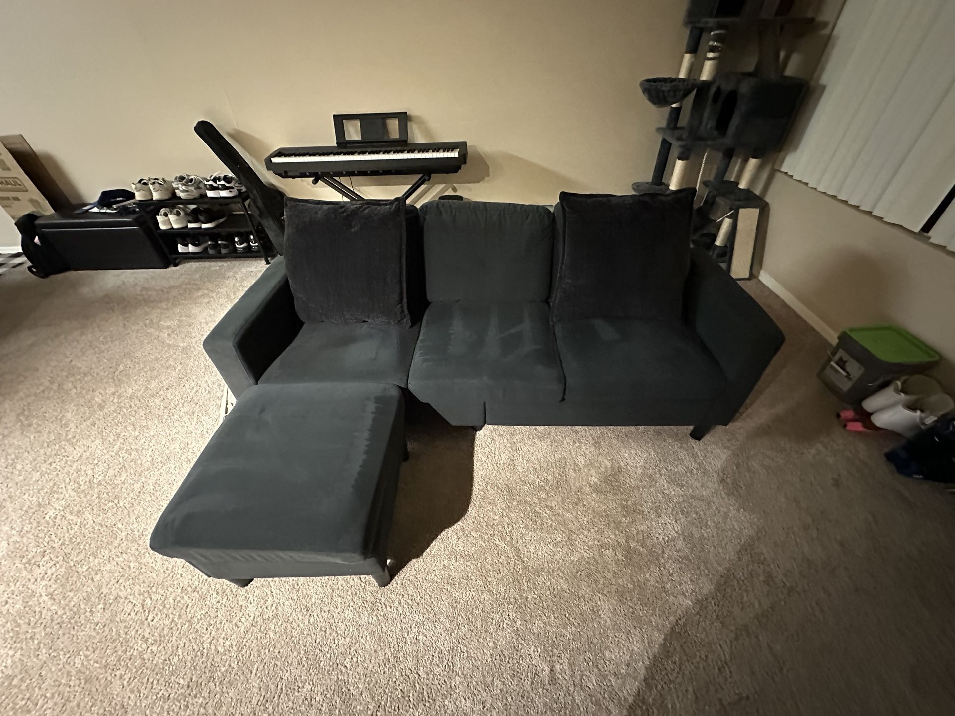 Dark grey L Shape Couch With ottoman And Dark grey Pillows.