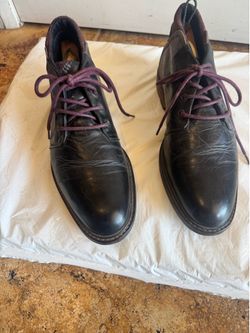 Cool black leather men's lace-up dress boots with subtle burgundy accents. Smooth leather upper offers a polished look. Burgundy laces add a refined c
