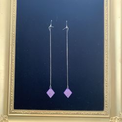 Gold tone dangle serpentine earrings with purple diamond shape discs