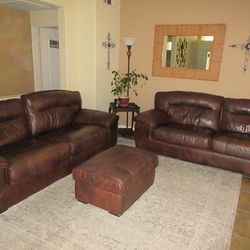 Brown leather couches and ottoman and table