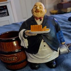Portly French Waiter With Bread And Wine Standing Near Wine Barrelk