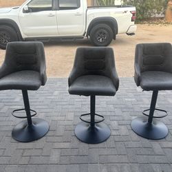 Three gray and black swivel barstools