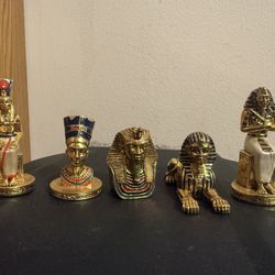 gold-plated, Egyptian-themed chess pieces, likely a set such as the Franklin Mint King Tutankha.
