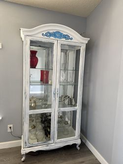 ♥️GORGEOUS white-painted cabinet or curio cabinet featuring glass panels and a distressed finish with blue decorative accents