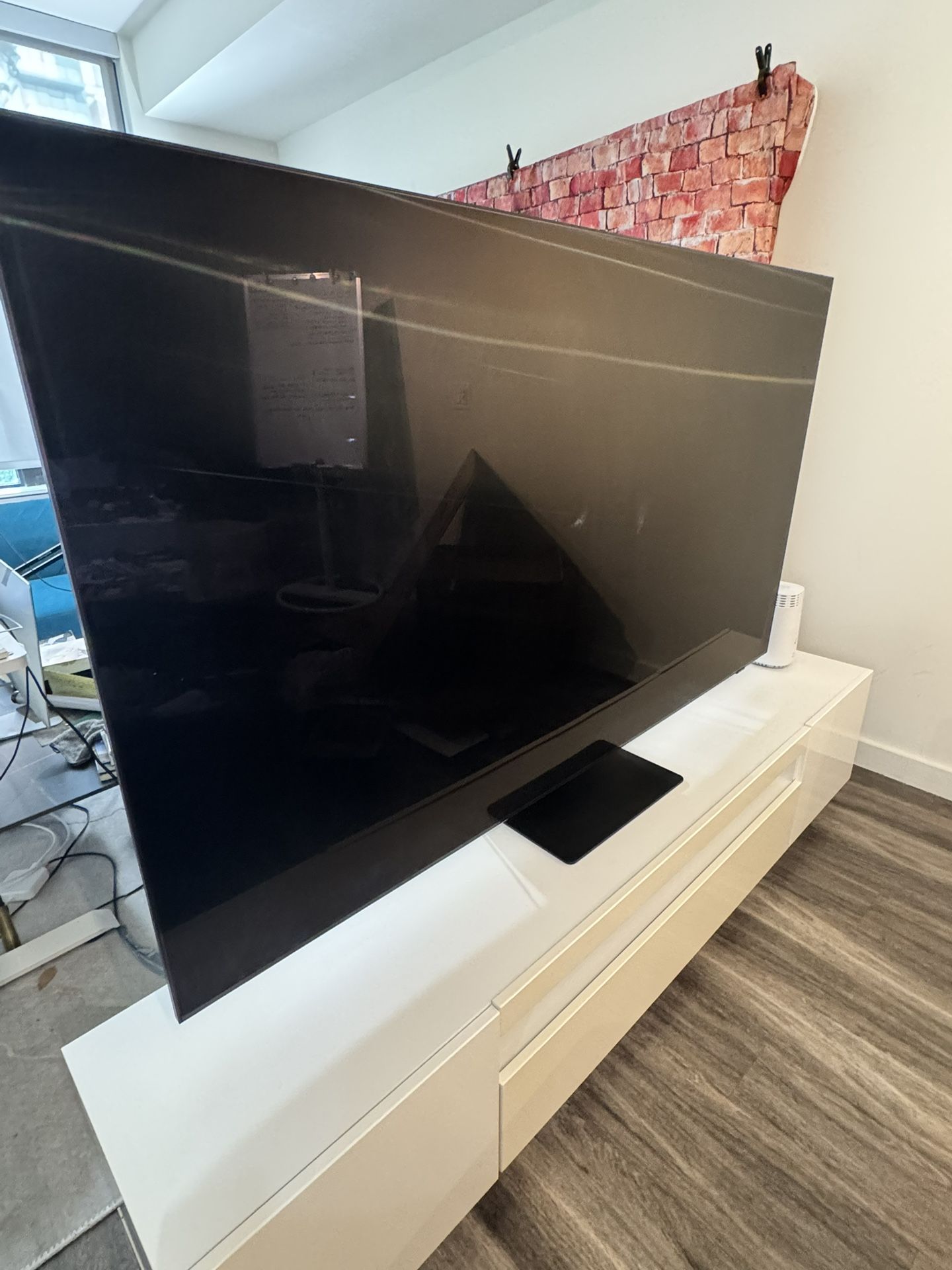 URGENT SALE: SAMSUNG 4K - 75" TV with a sleek white TV stand with built-in storage space