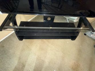 TV stand used made of tempered glass and wood.