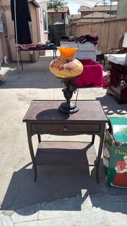 Vintage table with two beautiful lamps I’m only displaying one lap the lamps turn three different ways. I’m selling both items for 60 bucks. All three