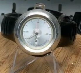 vintage Nike Oregon analog watch featuring a round brushed aluminum case and a silver dial.
