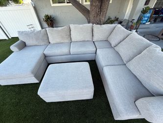 living space U-shaped sofa/couch in very good condition, with ottoman.