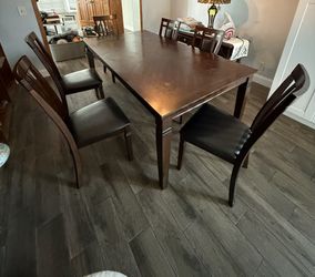 Dark Brown wood dining table Includes 6 cushioned chairs 