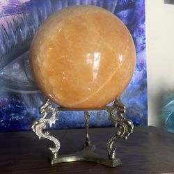 Polished crystal sphere on stand with dragons