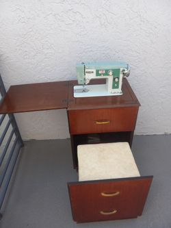 Vintage Visetti mint cream electric sewing machine with a wooden cabinet chair