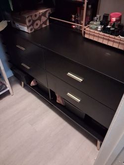 Un dresser  negro con agaraderas y paths color oro