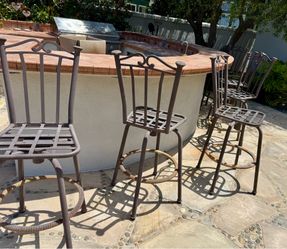 Six wrought iron swivel bar stools