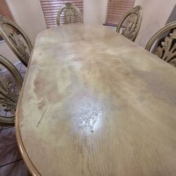 Table with six chairs and china.