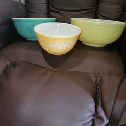 set of vintage Pyrex mixing bowls, featuring a yellow bowl with the "Butterfly Gold" pattern