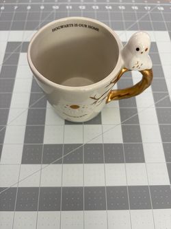 Ceramic mug with sculpted Hedwig owl handle featuring 'Hogwarts is Our Home' inscription
