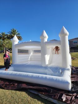 White bounce house with slide and ball pit