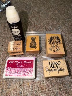 pre-owned wooden-mounted rubber stamps featuring designs like a pineapple and an angel. Stamper pad may have been purple. But the ink is black & purpl