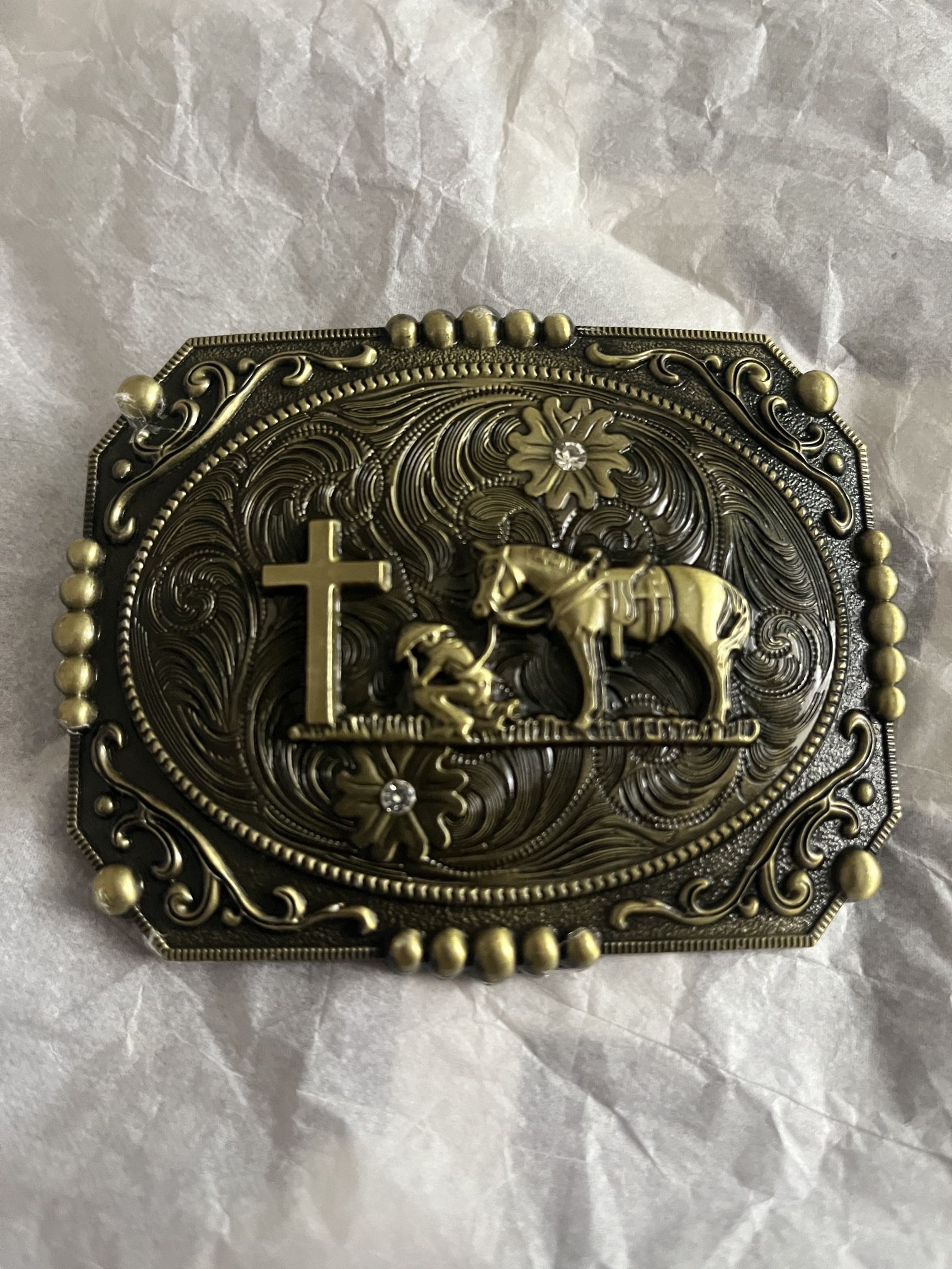 new gold patina western belt buckle featuring a cross and horse flag on the background