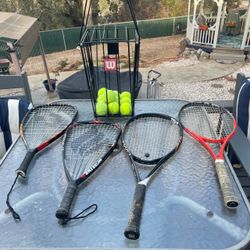 Four rackets with Wilson, tennis balls, and racket carrier