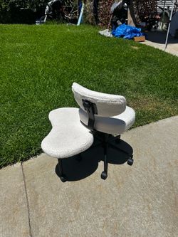 PINMOCO ergonomic cross-legged office chair featuring a wide, off-white bouclé seat and a matching backrest