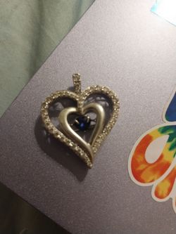 Silver heart pendant with infinity sapphire stone in the middle it shakes when it moves steadily shakes