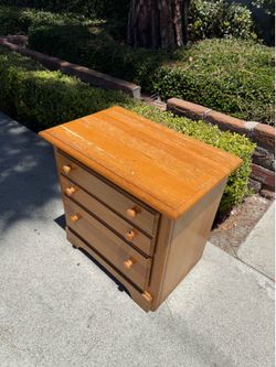 solid oak nightstand with light honey finish and traditional wooden knobs.