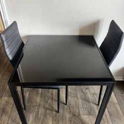Black glass dining table great conditions  Includes 2 chairs great conditions  delivery available 