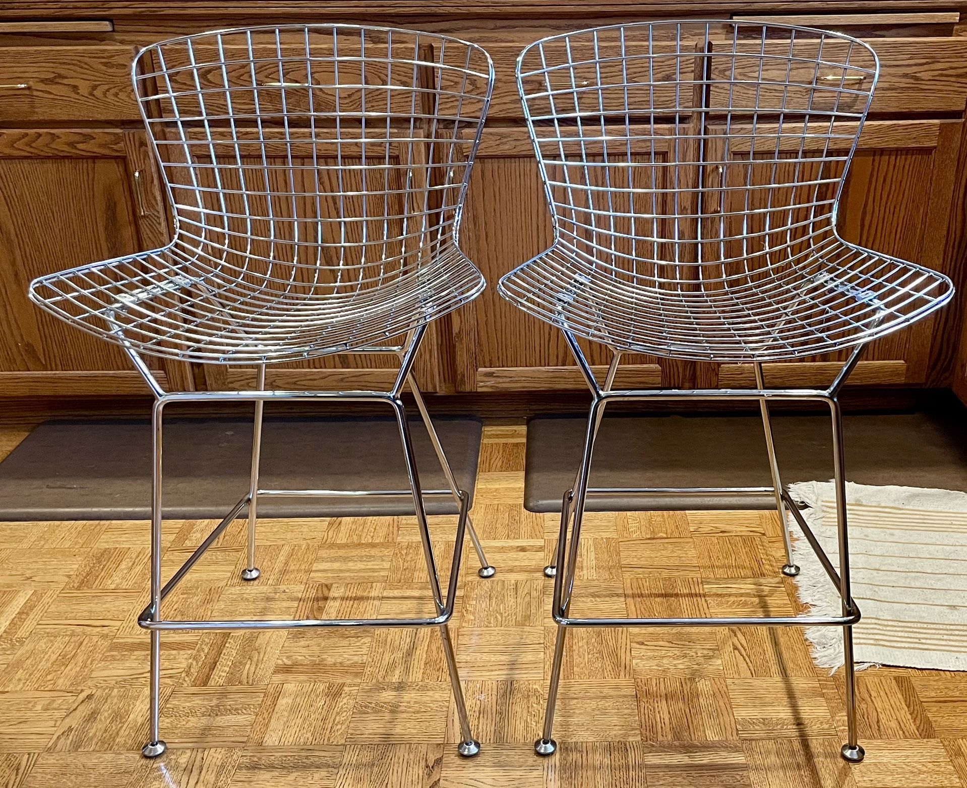 A pair of modern-style bar stools with chrome-plated wire