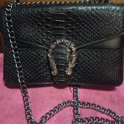Black Flaux-leather Snake Print Crossbody Bag With A Chain Strap And A Horsebit Style Buckle For Sale.