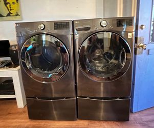 LG dark metallic front load washer and dryer set with pedestals