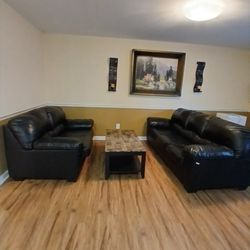 Small And Big Black Couch And A Table