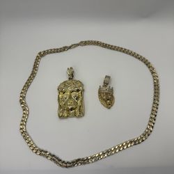 Una cadena bañada en oro y dos colgantes.