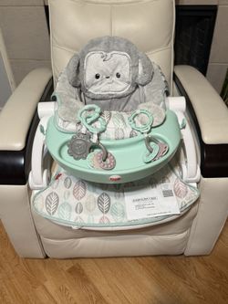 Portable floor seat with snack tray and toys.