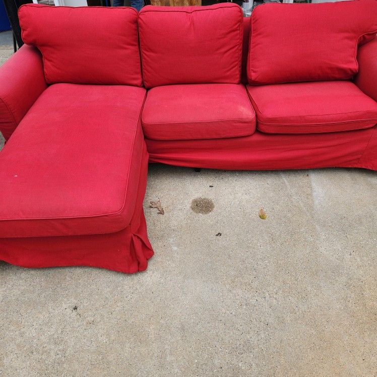 Red Ikea Couch Has Some Fading On The Sides From The Sun.