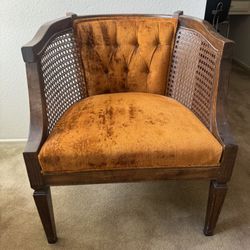mid-century modern cane barrel chair with tufted orange velvet cushions