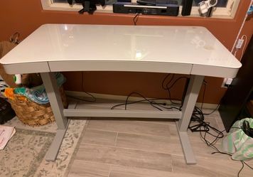 Glass standing desk with adjustable height feature