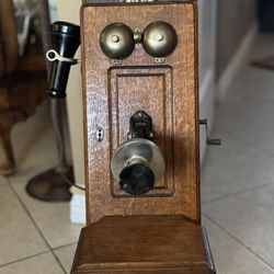 Antique magneto-crank wall-mounted telephone. Ca. 1900.  Inside, you can see the magnets and the copper coils that would generate the electrical charg