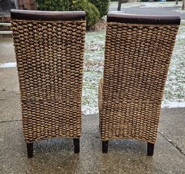 Two Solid wooden chairs with Wicker material seats and backs all in Excellent condition.
