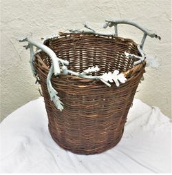 Vine basket with iron handles shaped like oak branches, leaves, acorns