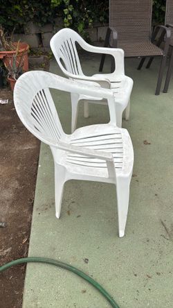 2 white plastic chairs