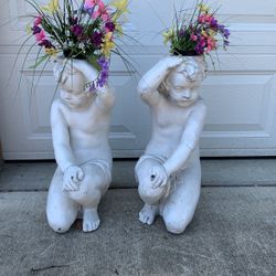 Two fiberglass cherubs plant stands