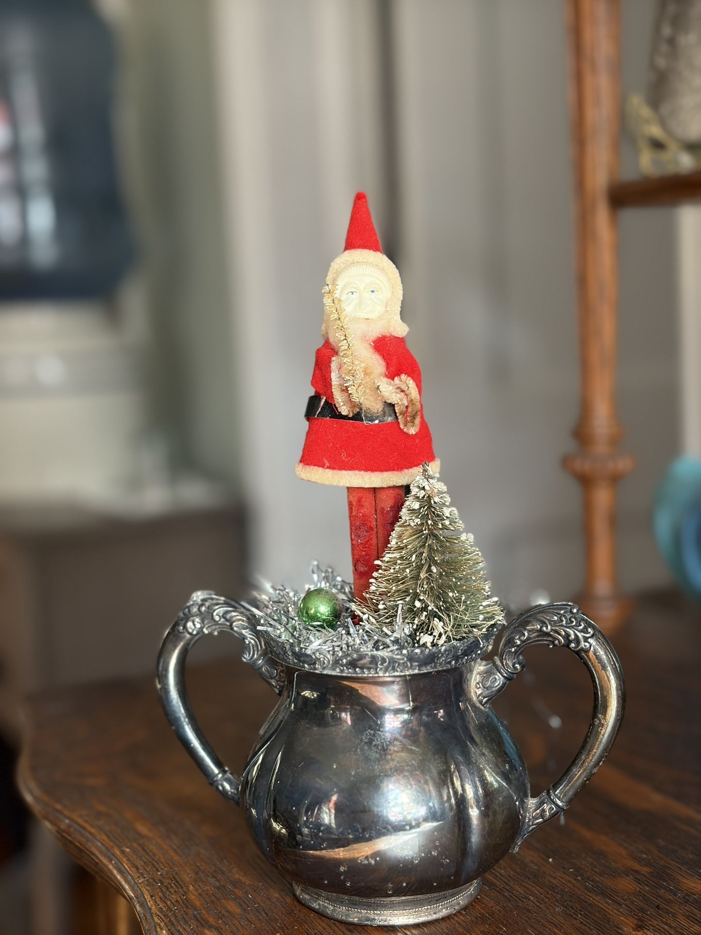 Antique/collectible Santa Claus standing on on a silver sugar bowl with Christmas tree