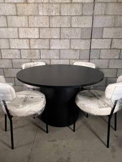 Fluted round black dining table with chairs