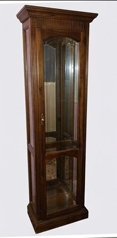 Tall curio cabinet with beautiful woodwork. This is a solid but lightweight piece of furniture built to last!