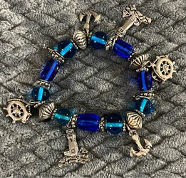 coastal-themed charm bracelet detailed with vibrant blue beads and antique silver maritime charms